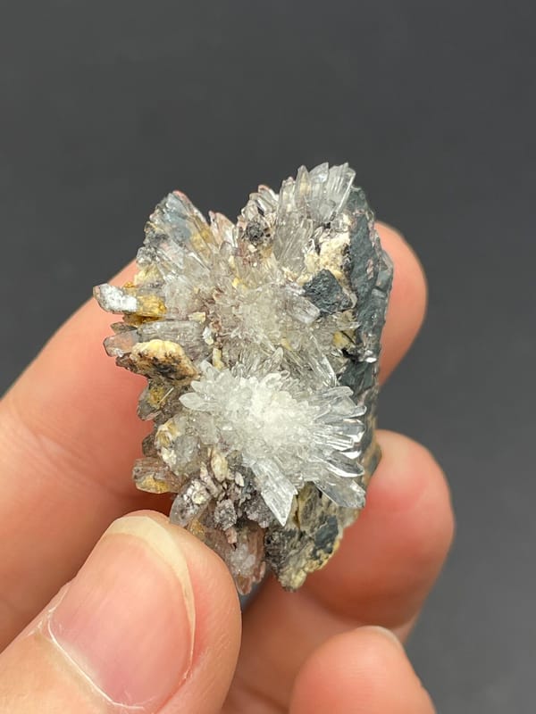 White creedite needle sprays on a grey-brown rock from Guizhou, China, reverse side