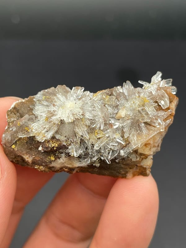 White creedite needle rosettes on brown rock from Guizhou, China, second angle