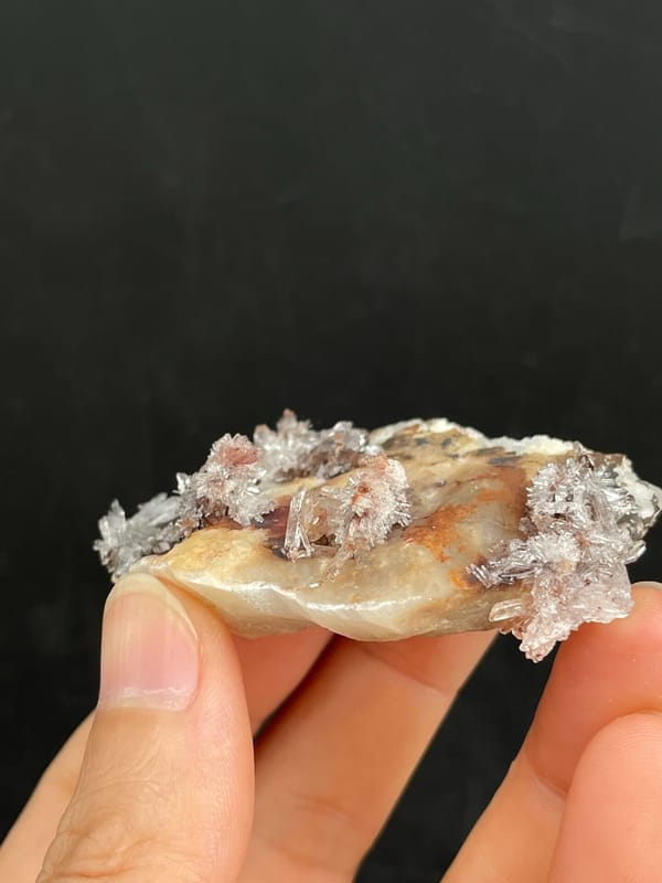 Cream creedite crust with rust-orange staining from Guizhou, China, close-up of the crystal faces