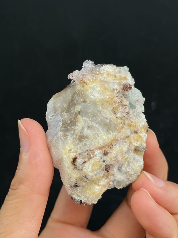 Cream creedite crust with rust-orange staining from Guizhou, China, detail of the matrix contact
