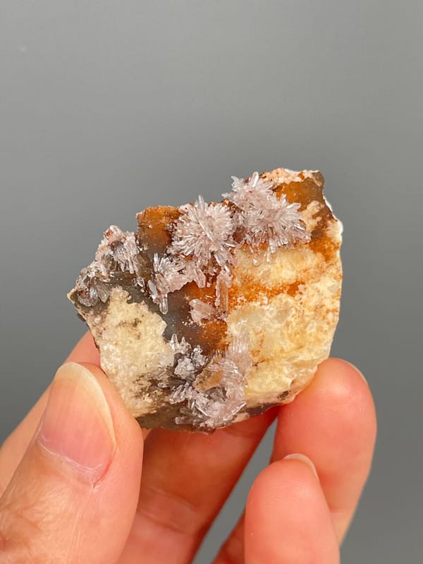Pale creedite needle sprays on ochre-orange rock from Guizhou, China
