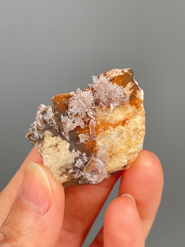 Pale creedite needle sprays on ochre-orange rock from Guizhou, China, reverse side