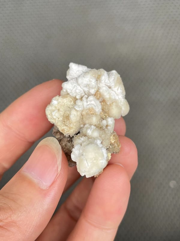 Cream popcorn-textured creedite crust from Guizhou, China, detail of the matrix contact
