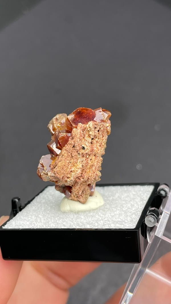 Blocky orange-brown vanadinite crystal group from Morocco, in a display box, second angle