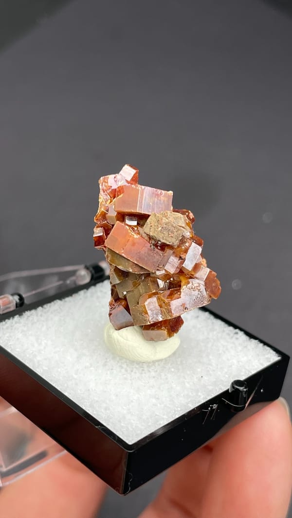 Blocky orange-brown vanadinite crystal group from Morocco, in a display box, top view