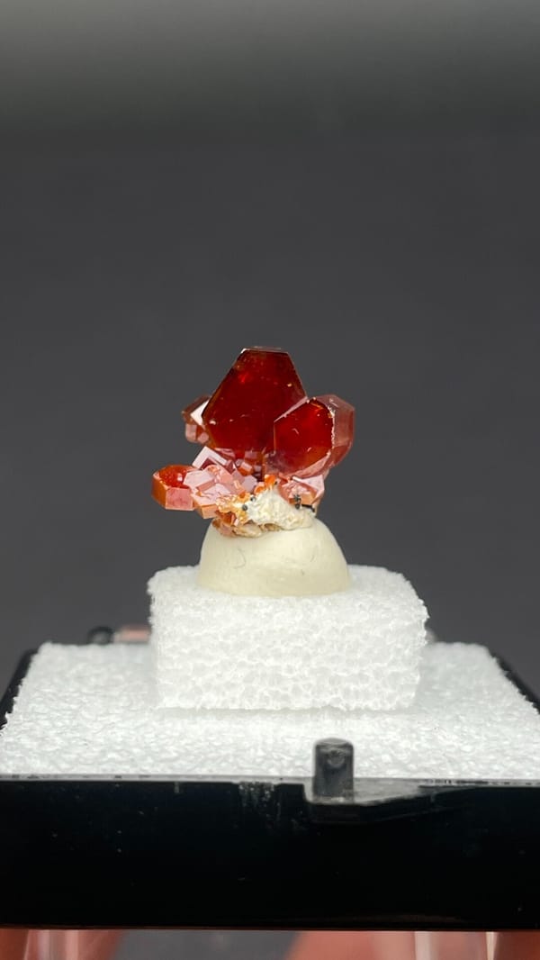 Bright red vanadinite crystal cluster from Morocco, in a display box
