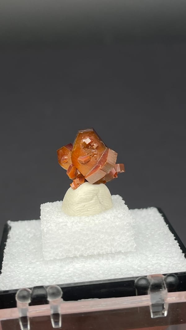 Bright red vanadinite crystal cluster from Morocco, in a display box, close-up of the crystal faces