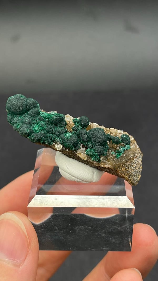 Dark green botryoidal malachite balls on a thin rock blade from DR Congo