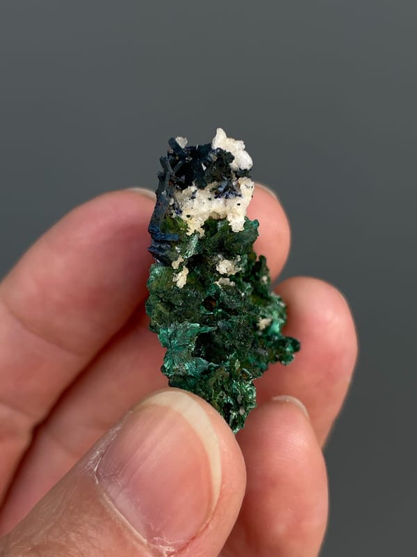Deep green malachite with white crystals on top from Anhui, China, close-up of the crystal faces