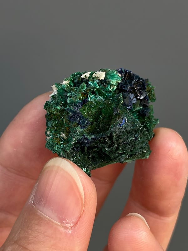 Deep blue azurite crystals in green malachite from Anhui, China, close-up of the crystal faces