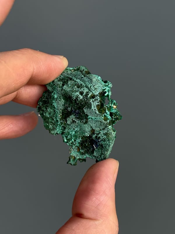 Green malachite crust with dark blue azurite patches from Anhui, China, detail of the matrix contact