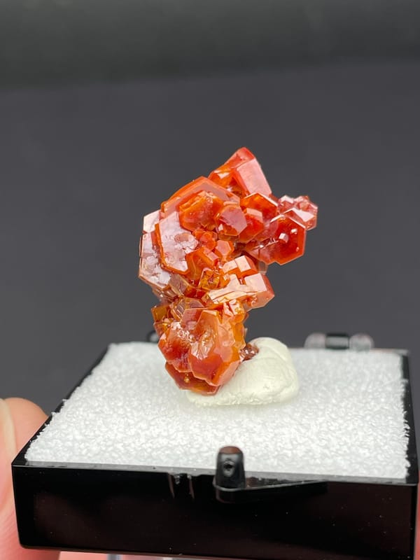 Red-orange vanadinite crystal cluster from Morocco, in a display box