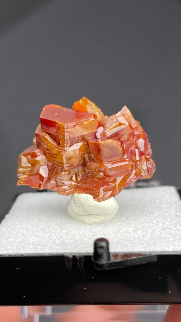 Stacked orange-red vanadinite plates from Morocco, in a display box