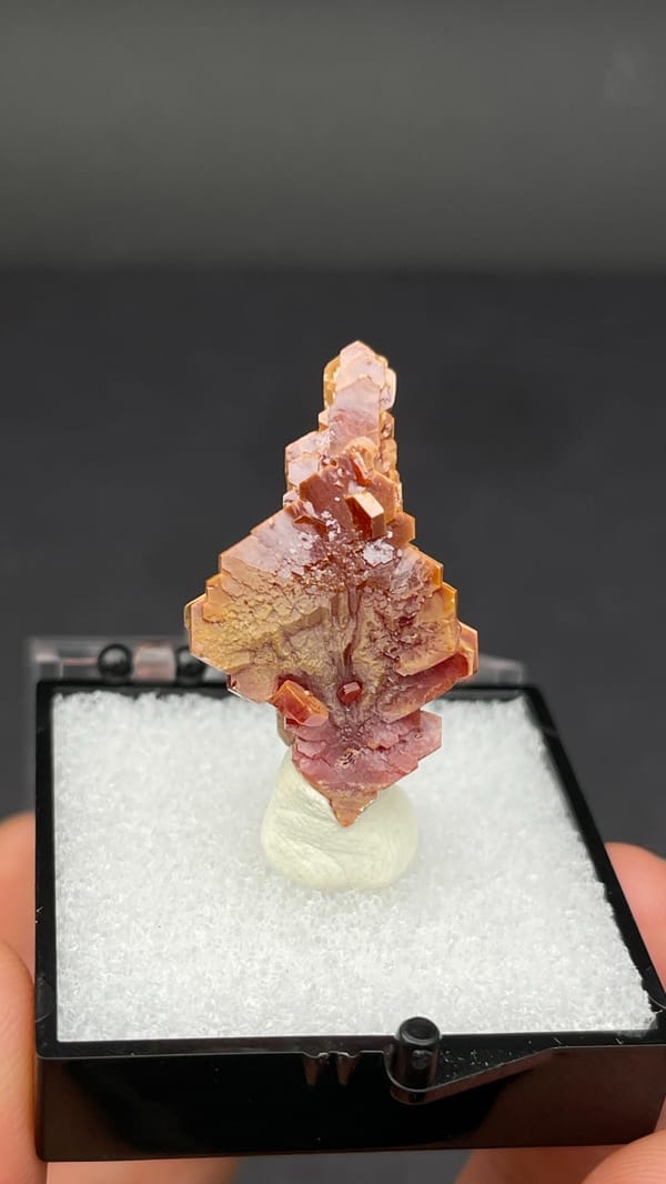 Stacked peach-red vanadinite crystal column from Morocco, in a display box