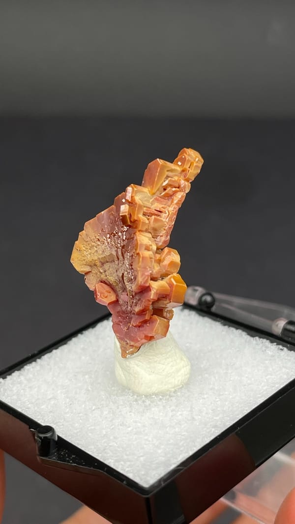 Stacked peach-red vanadinite crystal column from Morocco, in a display box, second angle