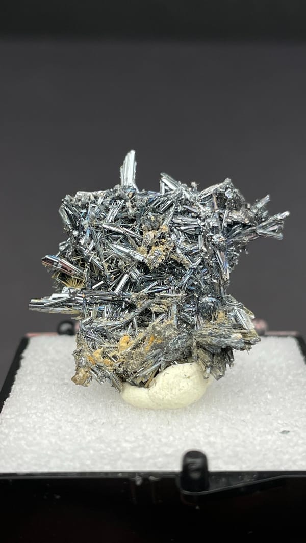 Silver-grey radiating stibnite needle spray from Guizhou, China, in a display box