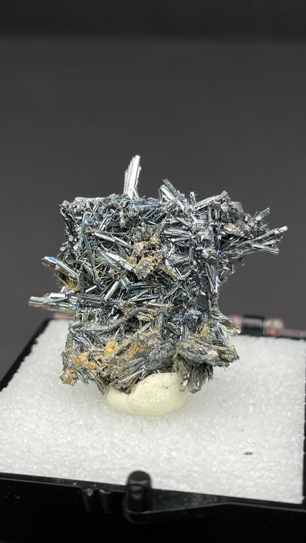 Silver-grey radiating stibnite needle spray from Guizhou, China, in a display box, second angle