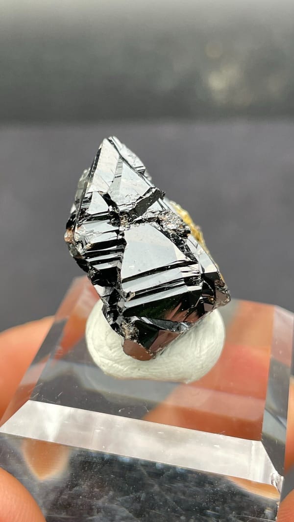 Black lustrous cassiterite crystal group from Xuebaoding, Sichuan, China, detail of the matrix contact