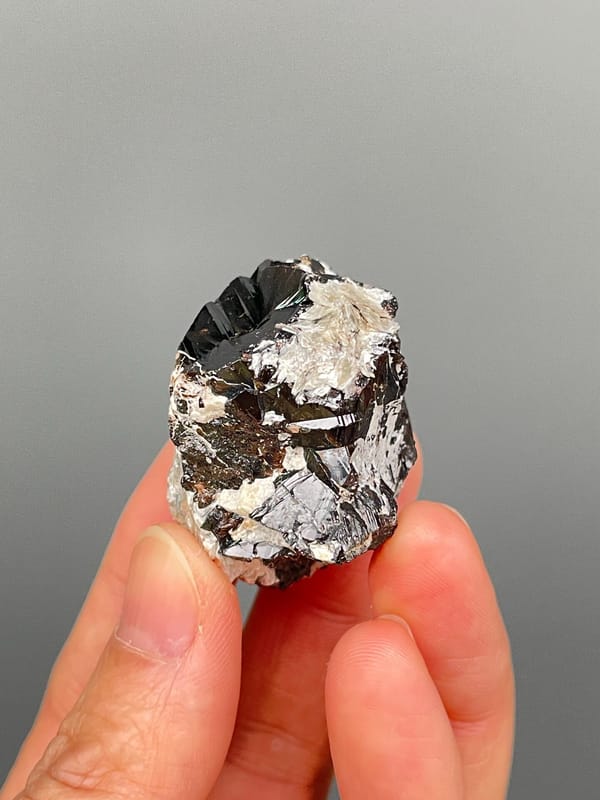 Black cassiterite crystal with silvery mica from Xuebaoding, Sichuan, China