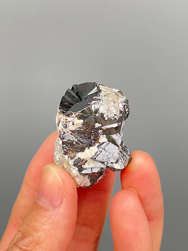 Black cassiterite crystal with silvery mica from Xuebaoding, Sichuan, China, close-up of the crystal faces