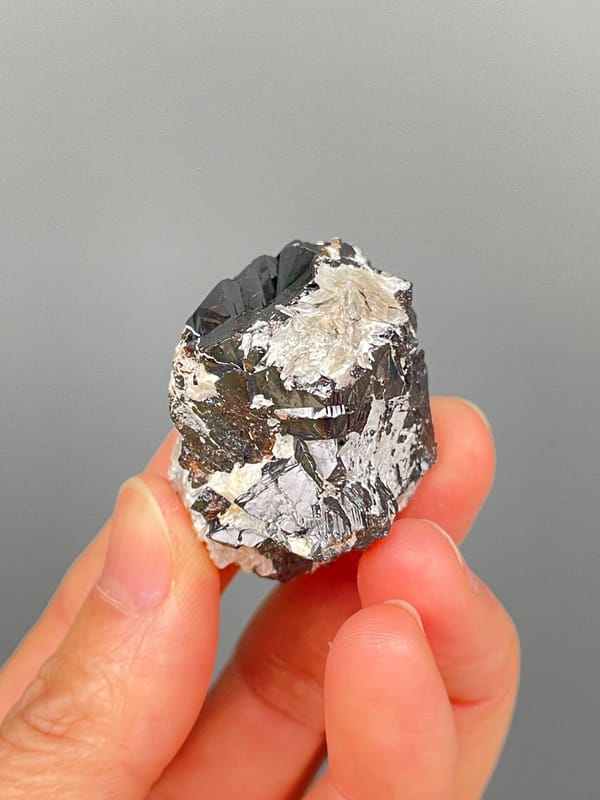 Black cassiterite crystal with silvery mica from Xuebaoding, Sichuan, China, side view