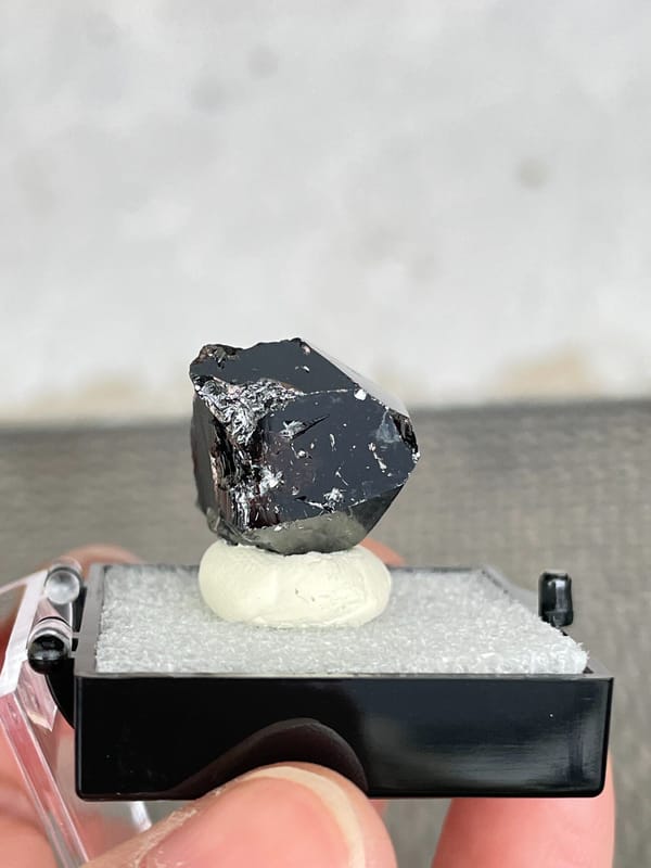 Glassy black cassiterite single crystal from Xuebaoding, Sichuan, China, close-up of the crystal faces