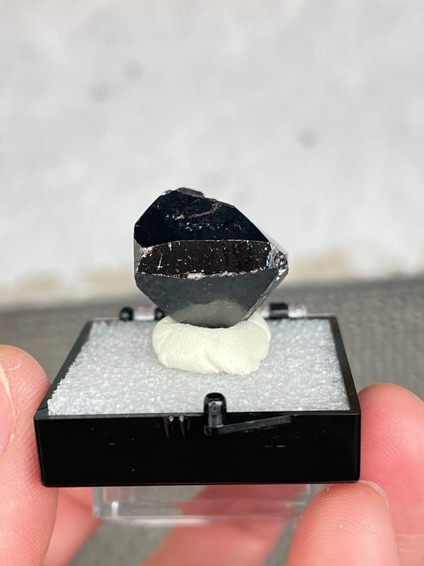 Glassy black cassiterite single crystal from Xuebaoding, Sichuan, China, detail of the matrix contact
