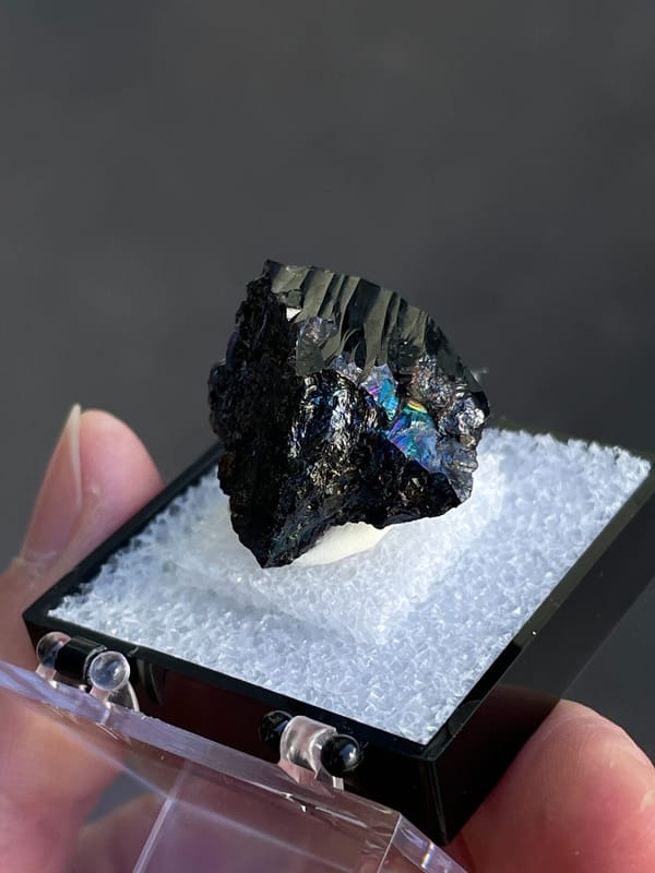 Wedge-shaped black cassiterite crystal from Xuebaoding, Sichuan, China, detail of the matrix contact