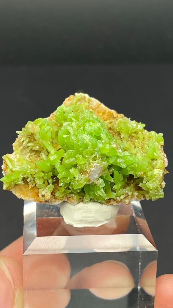 Apple-green pyromorphite crust on tan matrix from Guangxi, China, on a stand
