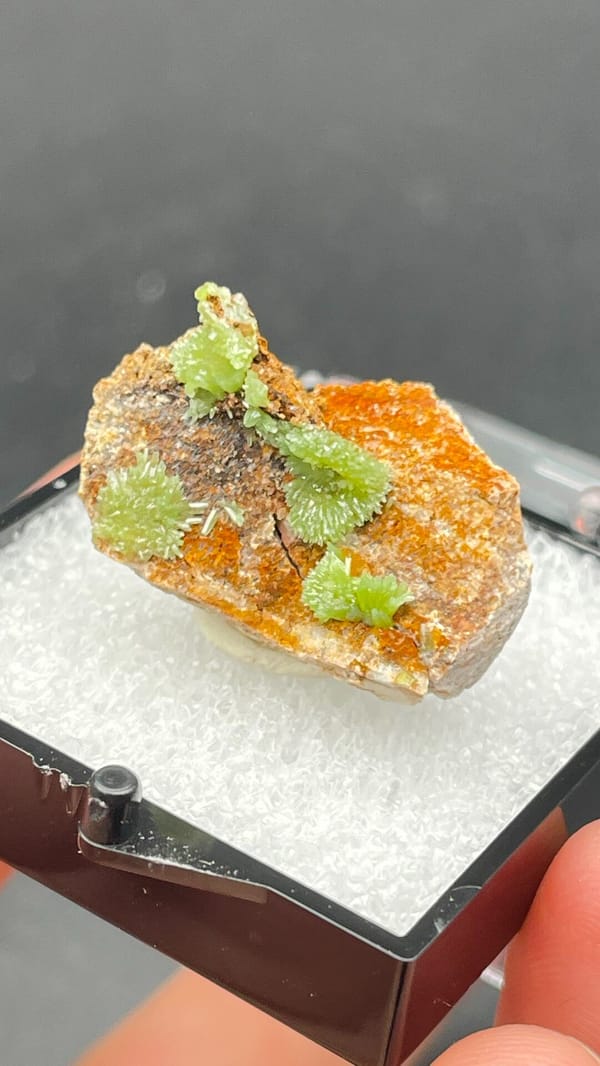 Apple-green pyromorphite tufts on an orange matrix slab from Guangxi, China, close-up of the crystal faces