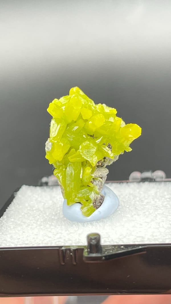 Vivid lemon-yellow pyromorphite cluster on dark base from Guangdong, China, detail of the matrix contact