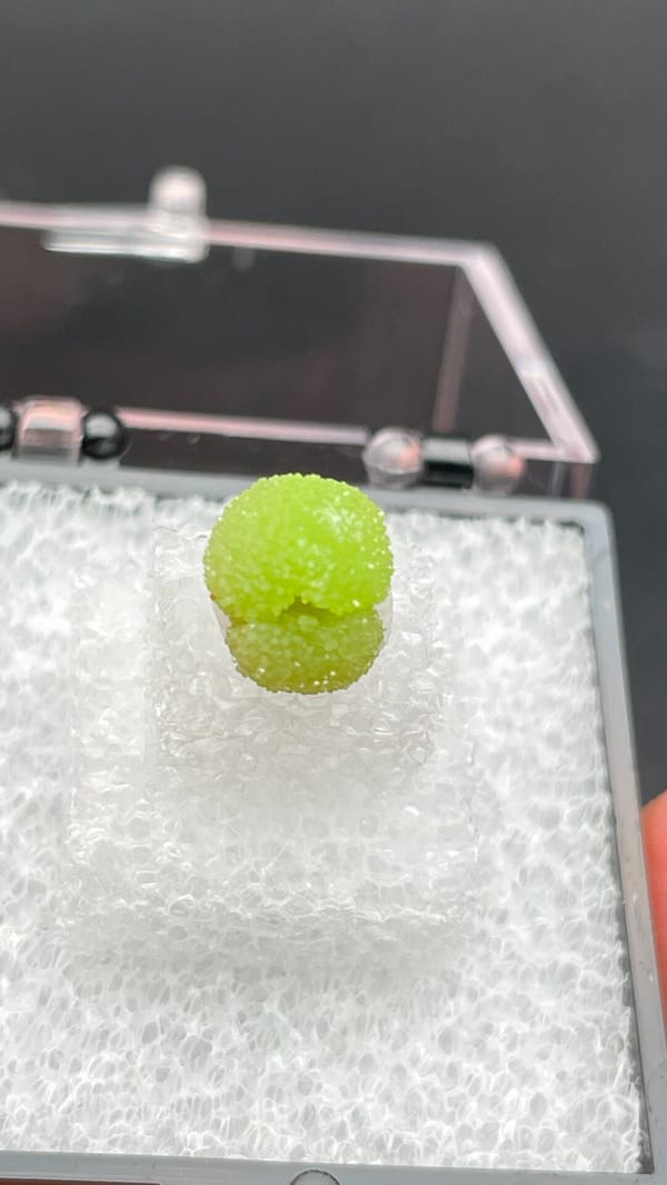 Single apple-green pyromorphite ball from Guangxi, China, in a display box, second angle