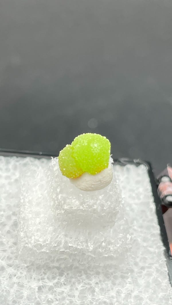 Single apple-green pyromorphite ball from Guangxi, China, in a display box, reverse side