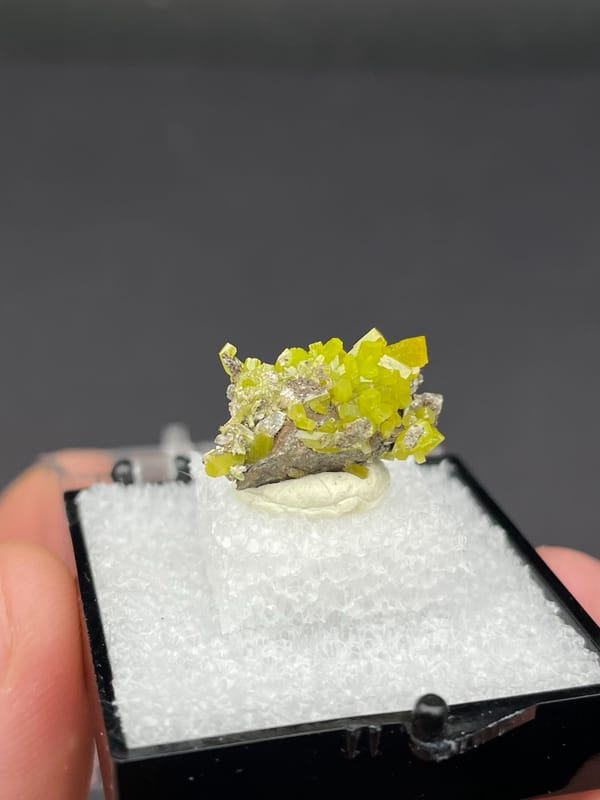 Yellow-green pyromorphite crust on grey matrix from Guangdong, China, in a box, reverse side