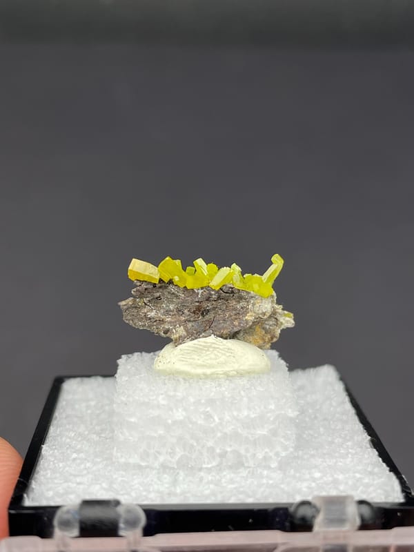 Yellow-green pyromorphite crust on grey matrix from Guangdong, China, in a box, top view