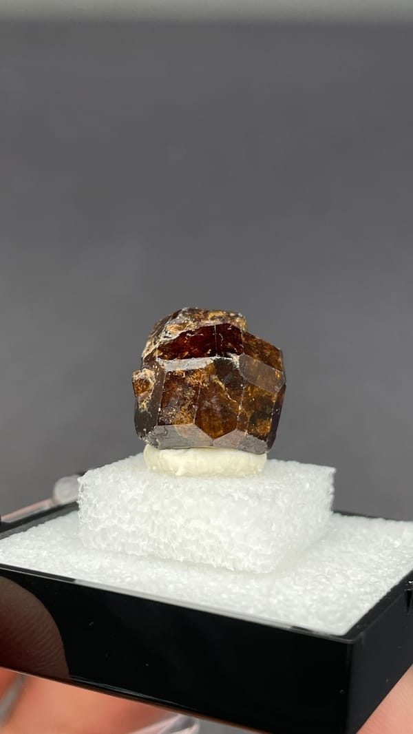 Amber-brown dodecahedral andradite garnet crystal from Handan, Hebei, China, detail of the matrix contact