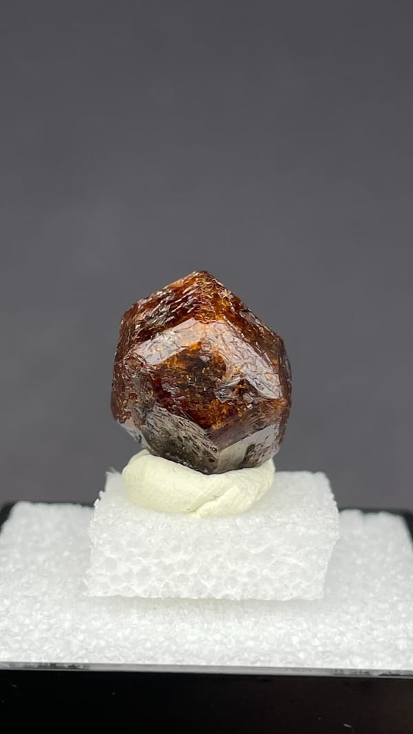 Dark red-brown dodecahedral andradite garnet from Handan, Hebei, China, in a box, second angle
