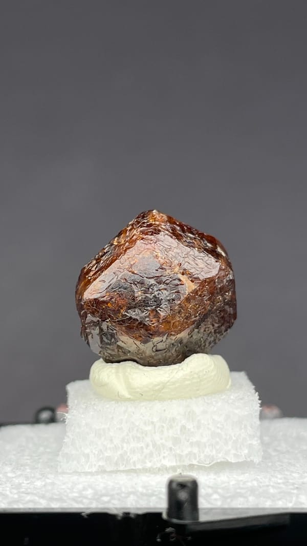 Dark red-brown dodecahedral andradite garnet from Handan, Hebei, China, in a box, top view