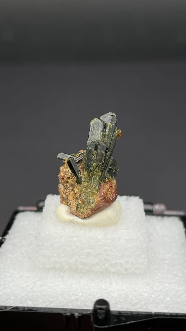 Fan of olive-green epidote blades on brown garnet from Handan, Hebei, China, detail of the matrix contact