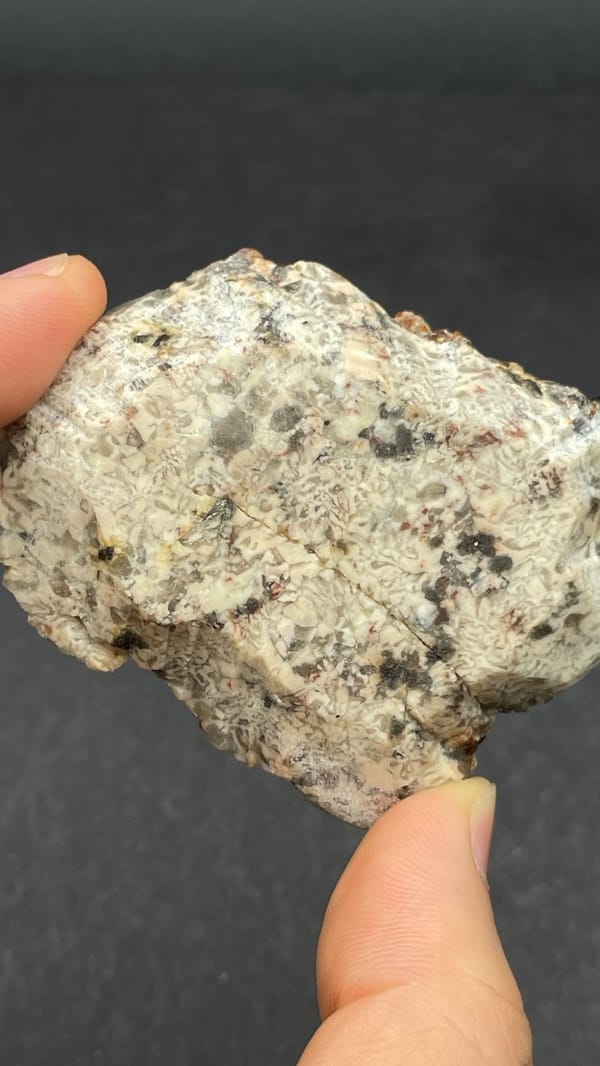 Dark red garnets with smoky quartz on a pale plate from Yunxiao, Fujian, China, detail of the matrix contact