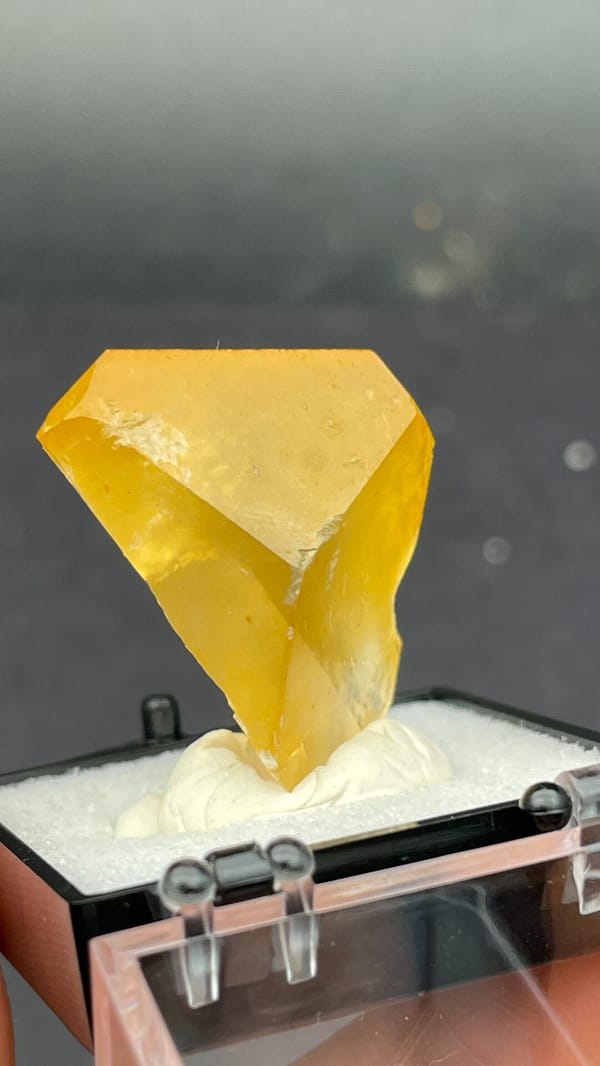 Amber-coloured baryte crystal from Jinkouhe, Sichuan, China, in a display box, reverse side