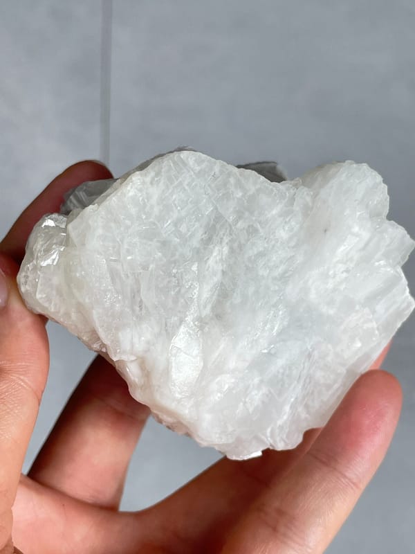 Large white-grey blocky baryte crystal group from Jinkouhe, Sichuan, China, detail of the matrix contact