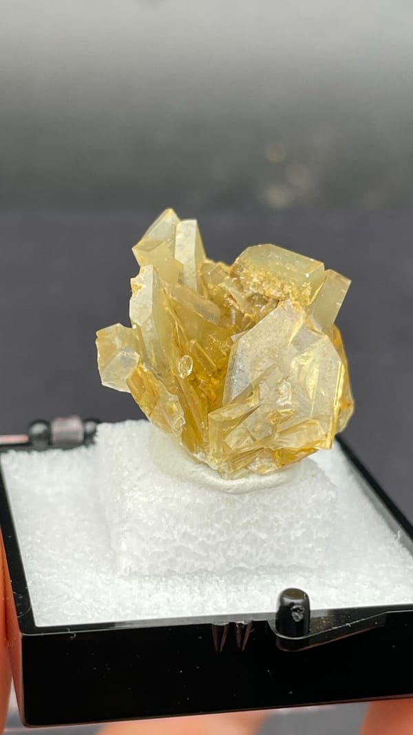 Golden-yellow baryte crystal cluster from Yunnan, China, in a display box, second angle
