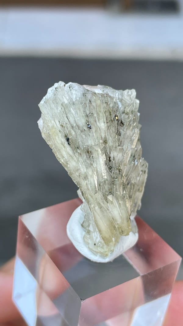 Pale grey-green bladed baryte from Morocco, on an acrylic stand, close-up of the crystal faces