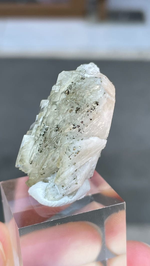 Pale grey-green bladed baryte from Morocco, on an acrylic stand, top view