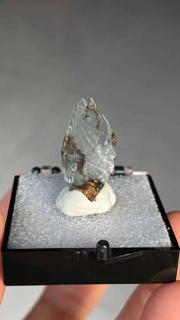 Pale blue transparent baryte crest on orange matrix from Morocco, in a box