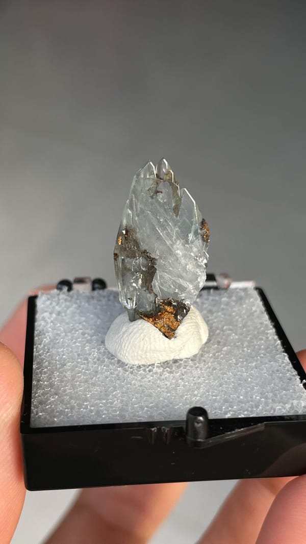 Pale blue transparent baryte crest on orange matrix from Morocco, in a box, reverse side