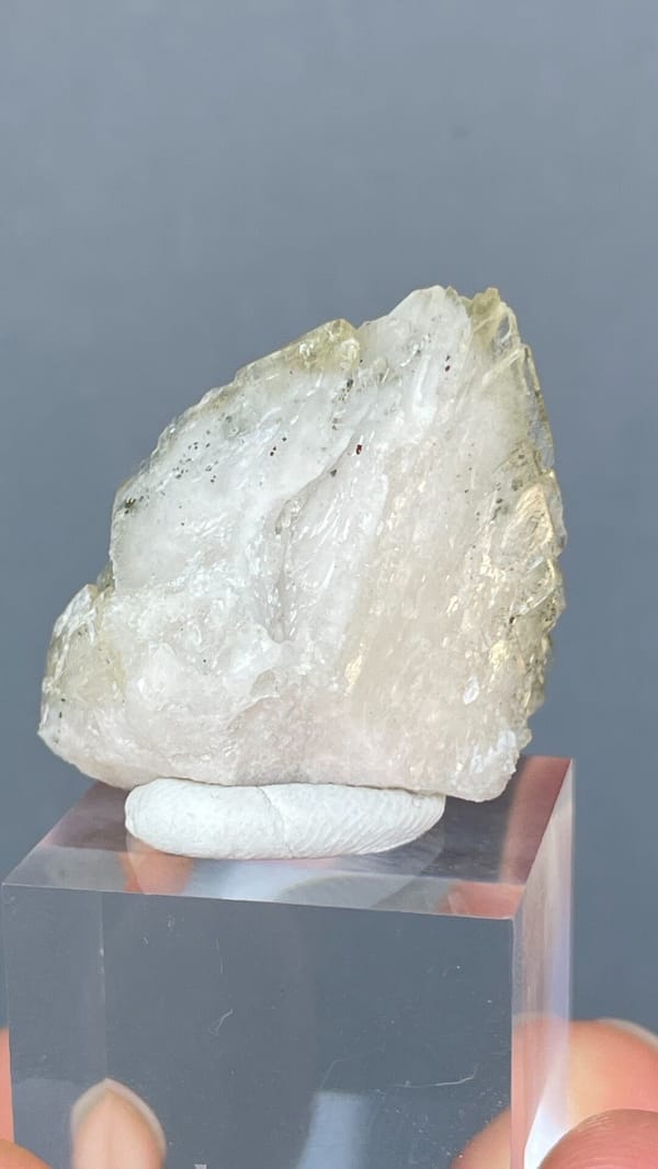 Pale straw-coloured bladed baryte fan from Morocco, on an acrylic stand, detail of the matrix contact
