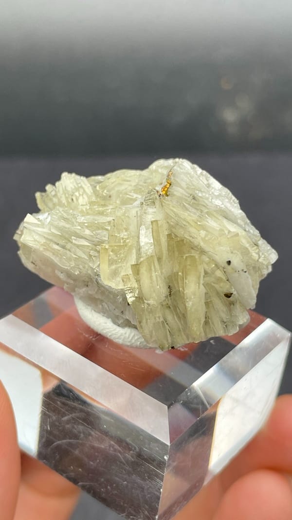 Pale straw-yellow bladed baryte fan from Morocco, on an acrylic stand, close-up of the crystal faces