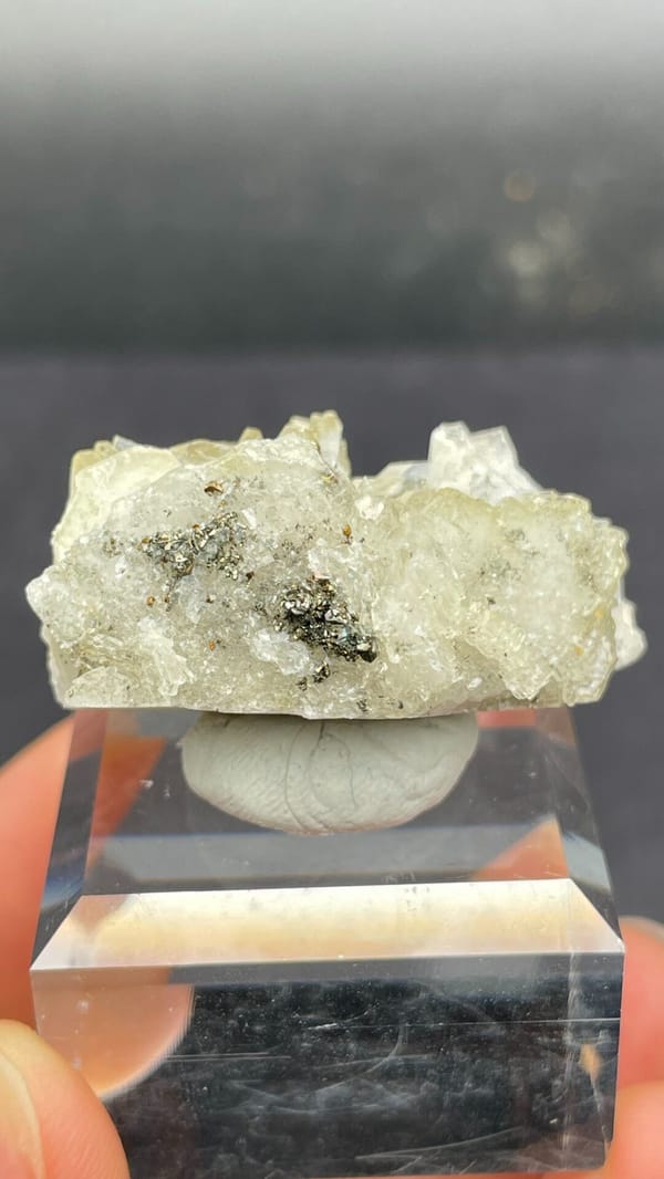 Pale straw-yellow bladed baryte fan from Morocco, on an acrylic stand, top view